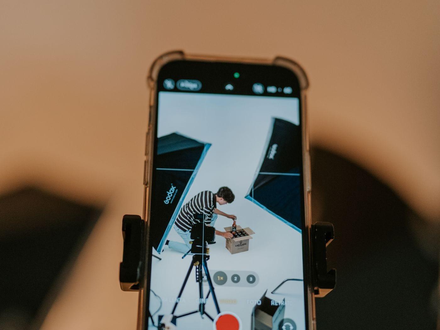 A phone on a mount, recording a box being opened.