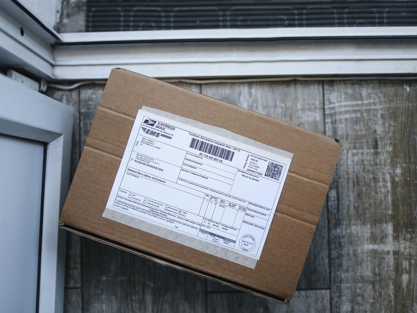 A shipping label on a sealed cardboard parcel, seen up close.